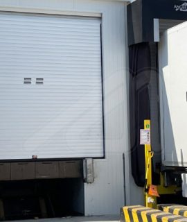 Puerta enrollable MIRTHERM-S para muelle de carga en centro logístico